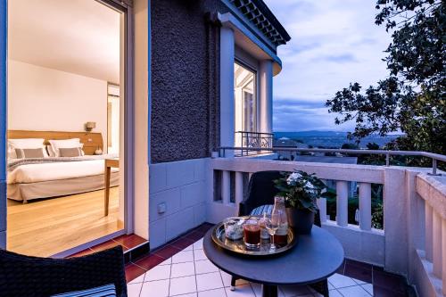 a balcony with a table and a bed and a bedroom at Villa Elisa M in Aubenas