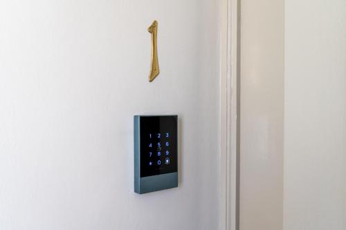 a remote control on a white wall with a clock at Donna Zaira rooms&suites in Maglie