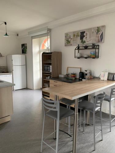 une cuisine avec une grande table et des chaises en bois dans l'établissement Appartement 120m2, à Aleçon