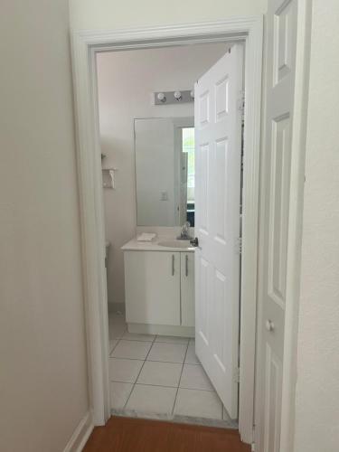 a white bathroom with a sink and a mirror at Mia in Miami