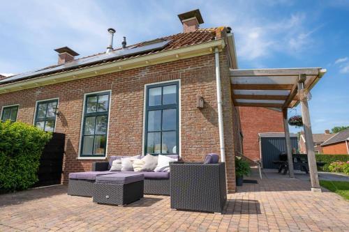 a brick house with a couch in front of it at Thuis in Sauwerd in Sauwerd