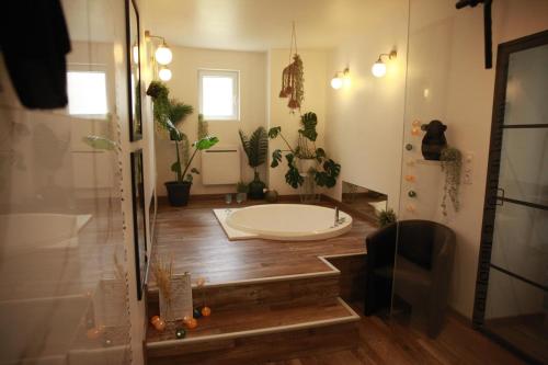 La Ferrière-DuvalにあるLoveroom atypique en duplex avec balnéo ronde et secret'roomのバスルーム(バスタブ、鉢植えのシャワー付)