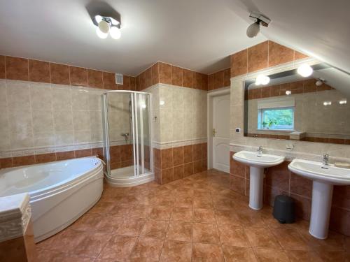 bagno con 2 lavandini, vasca e doccia di Pokoje na Lipowej 2 a Połaniec