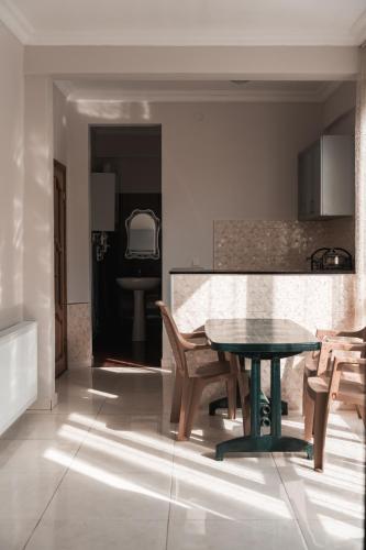 a kitchen with a table and chairs in a room at Nargiz's Guest House in Batumi