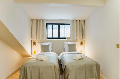 une chambre avec deux lits avec des serviettes dessus dans l'établissement Spacious LOFT with SPA - 4BR-8P - Montmartre, à Paris