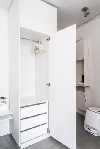 La salle de bains est pourvue d'un placard blanc et de toilettes. dans l'établissement Louvre Innocent Apartment, à Paris