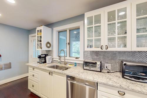 a kitchen with white cabinets and a sink at Bayview in Truro