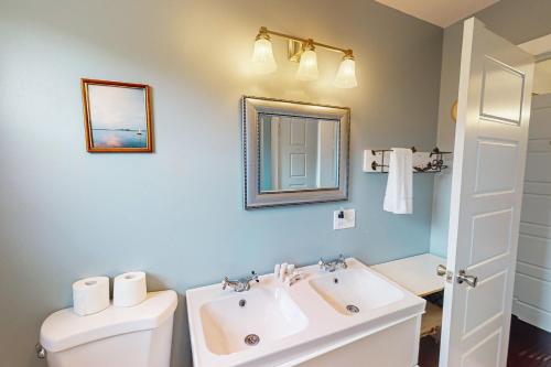 a bathroom with a sink and a toilet and a mirror at Bayview in Truro