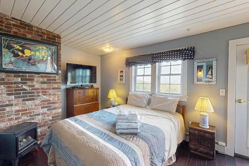 a bedroom with a bed and a brick wall at Bayview in Truro
