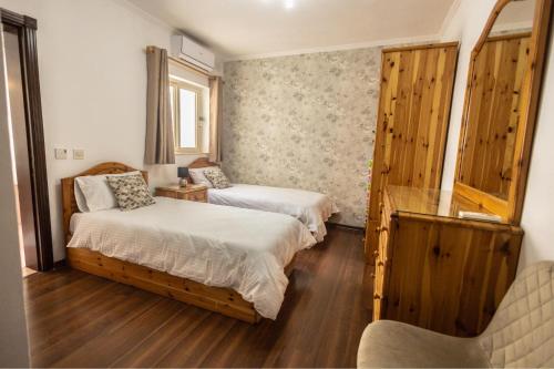 圣朱利安斯3 bedroom Apartment in the centre of St Julians的一间卧室配有两张床和椅子