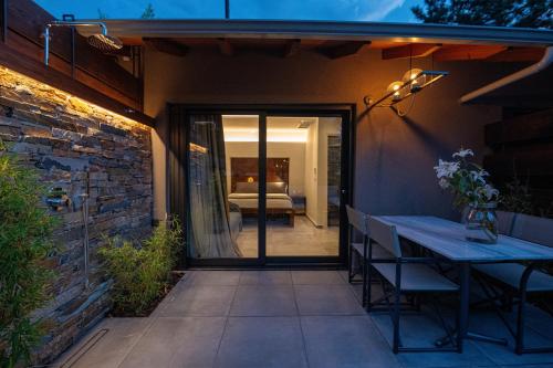 a patio with a table and chairs next to a building at Sylvia Camping & Luxury Suites, Panel Hospitality Homes & Villas in Litochoro