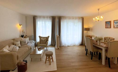 un salon avec un canapé et une salle à manger dans l'établissement Les Jardins de la Mer - Appart face Nausicaa, Plage, Netflix, à Boulogne-sur-Mer