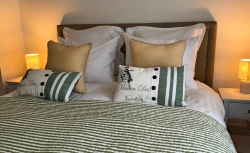 un lit avec un tas d'oreillers dessus dans l'établissement Les Jardins de la Mer - Appart face Nausicaa, Plage, Netflix, à Boulogne-sur-Mer