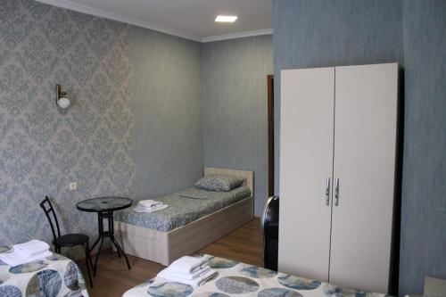 a room with two beds and a cabinet and a table at Guesthouse Evergreen in Oni