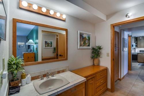 un baño con lavabo y espejo en Cozy Ski-InandSki-Out Winter Park Condo with Pool!, en Winter Park