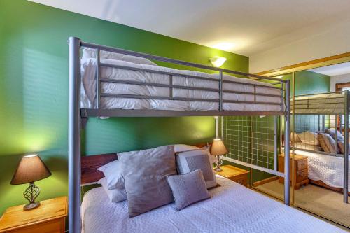 1 dormitorio con 2 literas y una pared verde en Cozy Ski-InandSki-Out Winter Park Condo with Pool!, en Winter Park