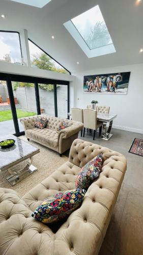 a living room with two couches and a skylight at Grass Court Terrace - walking distance from Wimbledon Championships in London
