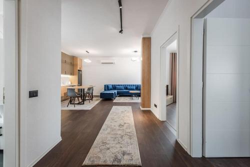 a living room with a blue couch and a table at The City Center Penthouse by PS in Durrës