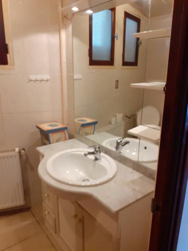 une salle de bain avec un lavabo et un miroir dans l'établissement Appartement bord de mer, à Portiragnes