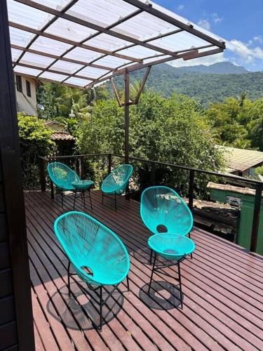 a group of blue chairs and tables on a deck at La Vista Suíte Tripla Vista Mar in Abraão