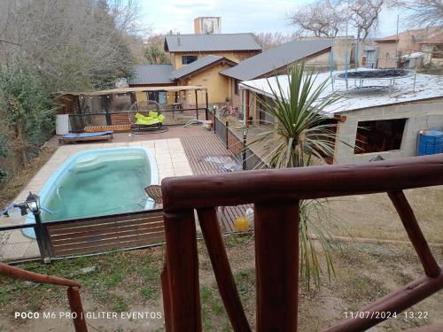 Un patio trasero con piscina y una casa. en Amphu, en La Falda