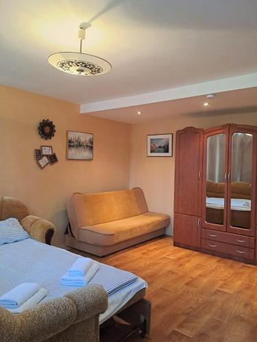 a living room with a bed and a couch at Sunny flat 250m from the beach in Liepāja