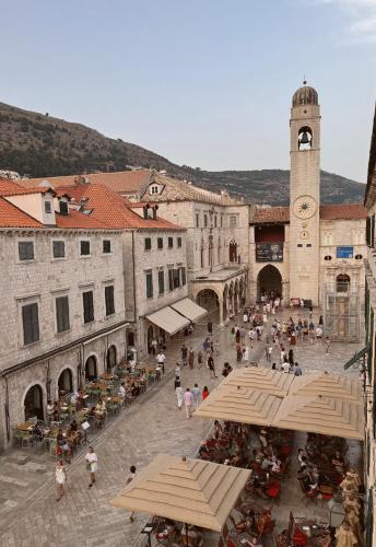 a group of people sitting in a plaza in a city at Velut Home Bural in Dubrovnik
