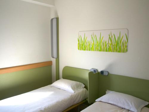 two beds in a room with green and white at Ibis Budget Toulon Centre in Toulon