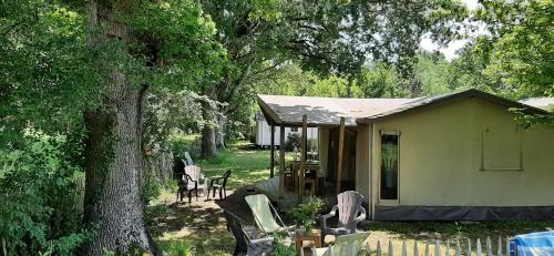 une petite maison avec une table et des chaises dans une cour dans l'établissement eco lodge 4 etoiles cotton prenium, à Vendays-Montalivet