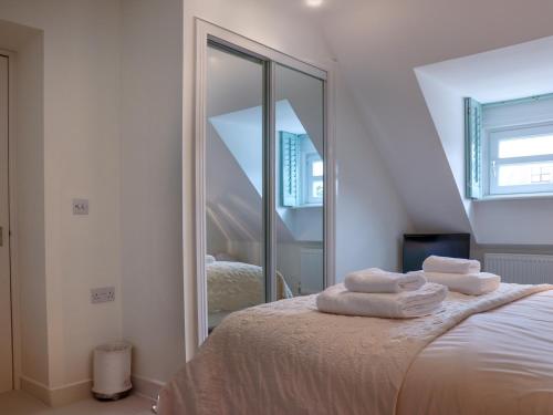 a bedroom with a mirror and a bed with towels at Celeste in Carbis Bay