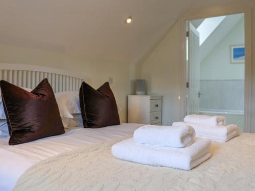 a white bed with towels on top of it at Celeste in Carbis Bay
