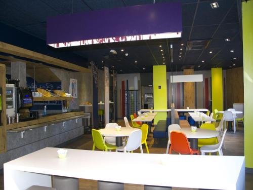 
a dining room with tables and chairs in it at Ibis budget Toulon centre in Toulon
