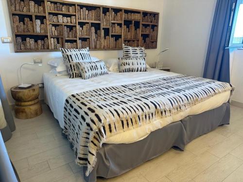 une chambre avec un grand lit avec des oreillers dessus dans l'établissement CAMARU CANTU, à Bonifacio