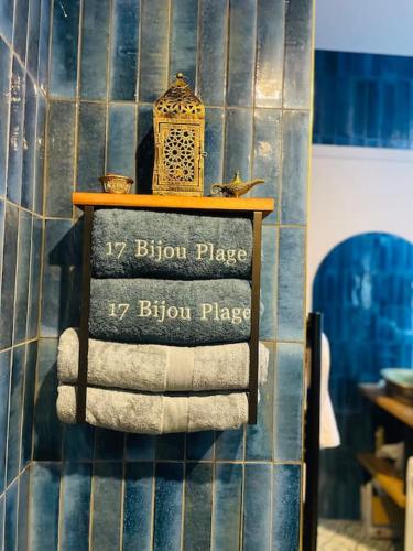 une étagère avec des serviettes sur un mur carrelé bleu dans l'établissement 17Bijou-Plage, à Antibes