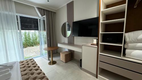a hotel room with a bed and a desk and a television at Anchor Luxury Rooms in Vlorë