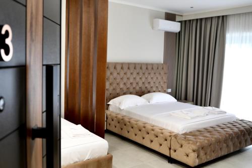 a bedroom with a large bed and a mirror at Anchor Luxury Rooms in Vlorë