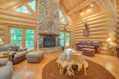 a living room with a fireplace in a log cabin at Lodge on 104 Acres with Fire Pit in Boyne City in Petoskey
