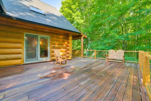 a cabin with two chairs on a wooden deck at Lodge on 104 Acres with Fire Pit in Boyne City in Petoskey