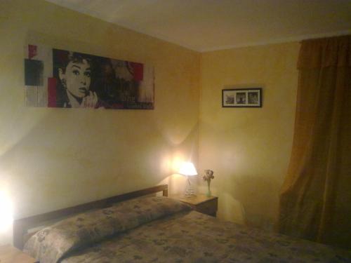 a bedroom with a bed with a lamp and a painting at Residence Regina in Marina di Gioiosa Ionica