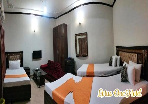 a hotel room with two beds and a chair at Lotus One Hotel in Lahore