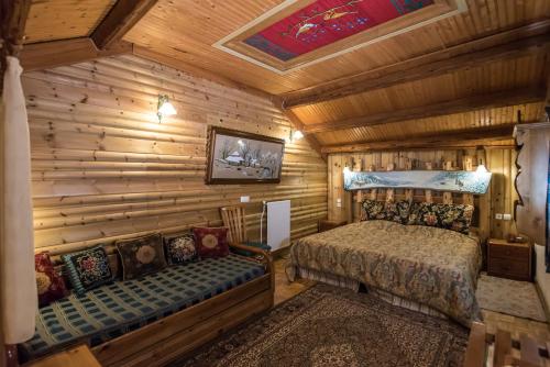 sypialnia w drewnianym domku z łóżkiem i kanapą w obiekcie I Gonia Tis Linas w mieście Áyios Nikólaos