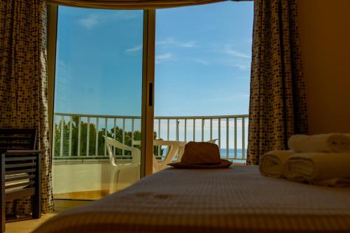 a bedroom with a large window with a view of the ocean at Hotel Garden in Praia a Mare