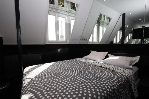 - une chambre avec un lit noir et blanc et des fenêtres dans l'établissement Studio de luxe, à Paris