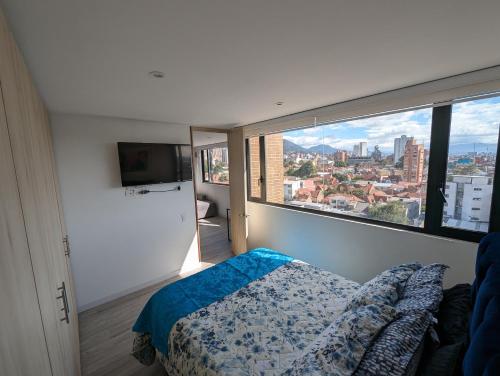 a bedroom with a bed and a large window at Nice flat in financial heart of Bogotá in Bogotá