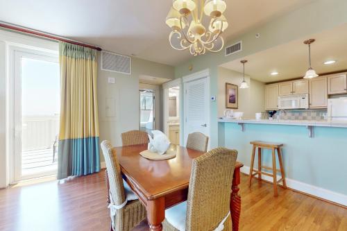 a kitchen and dining room with a wooden table and chairs at The Grand #2625 in Destin