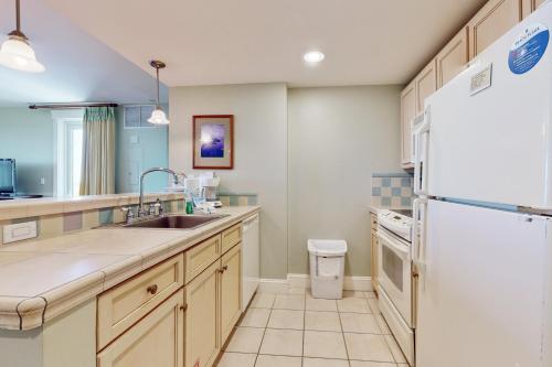 a kitchen with a sink and a refrigerator at The Grand #2625 in Destin