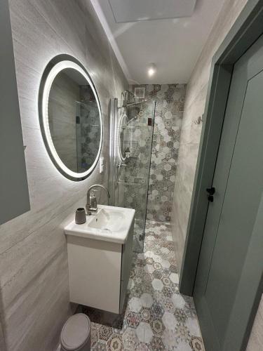 a bathroom with a sink and a shower and a mirror at Apartament Pastelowy in Głuszyca