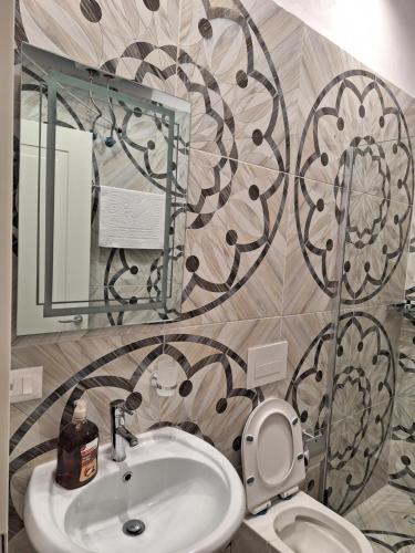 a bathroom with a sink and a toilet and a mirror at DEJA BLUE Cozy Apartments in Durrës