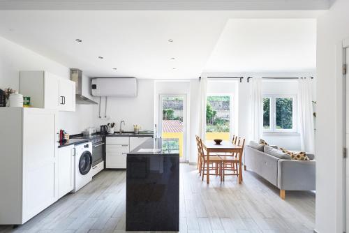 a kitchen and living room with a couch and a table at Sintra Sweet Apartment II - Free Parking in Sintra