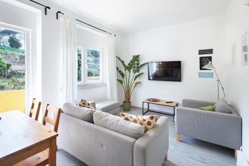 a living room with two couches and a table at Sintra Sweet Apartment II - Free Parking in Sintra